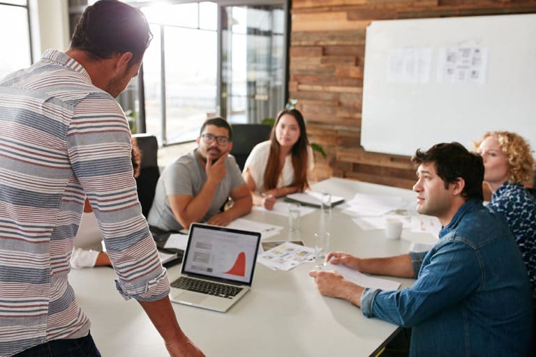 Man standing in front of team of coworkers